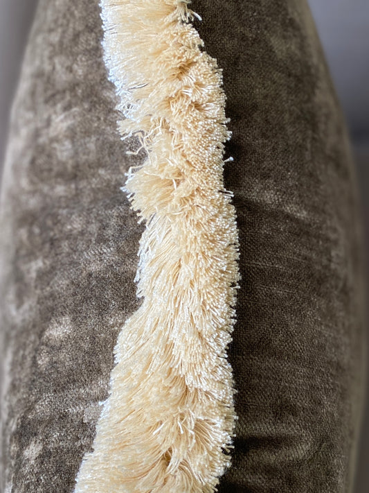 Close up of brown vintage feel velvet cushion with cream fringing.