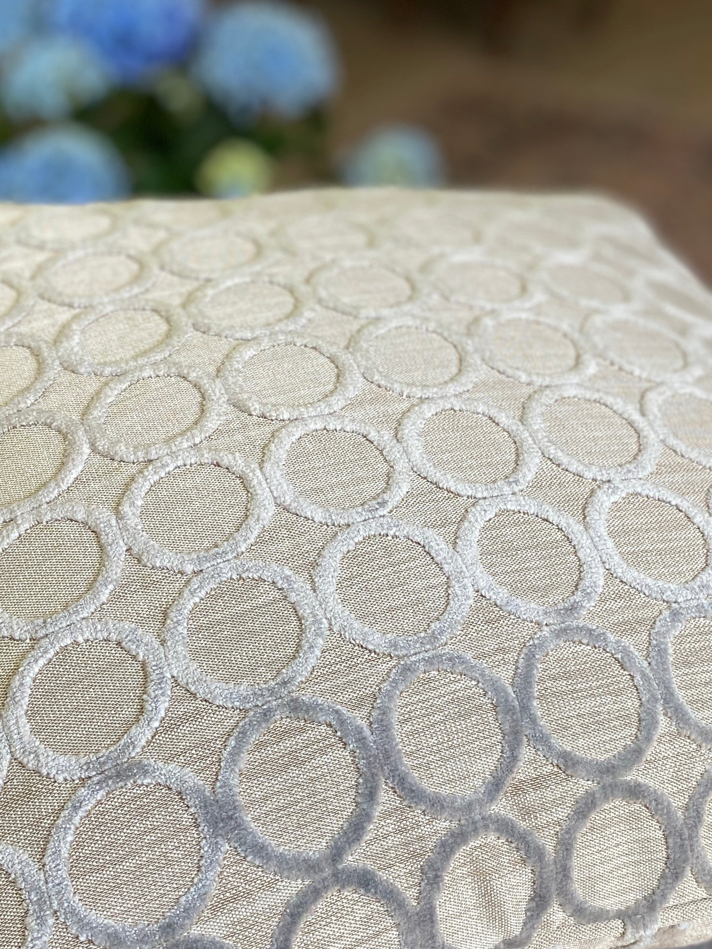 Close up of cushion lying flat and showing the circles in velvet with a silver grey background