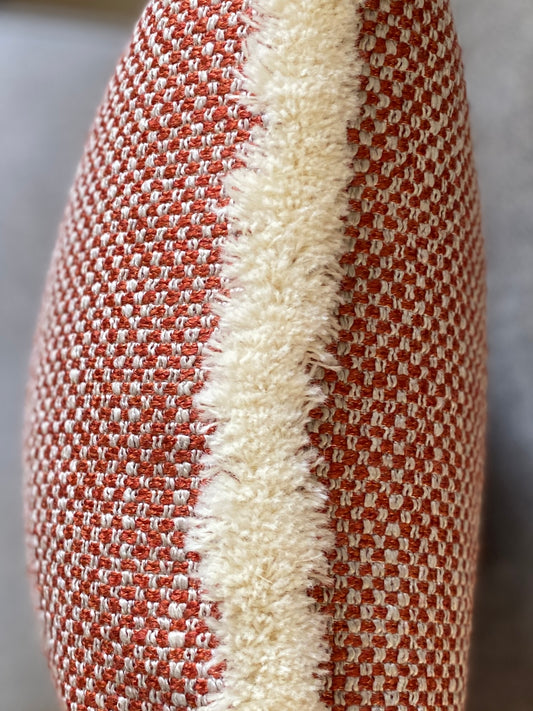 A close up to show to cream wool fringing on the chestnut and cream woven cushion.