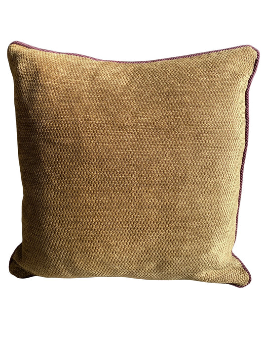 Textured burnished gold cushion with a wine cord trim on a white background