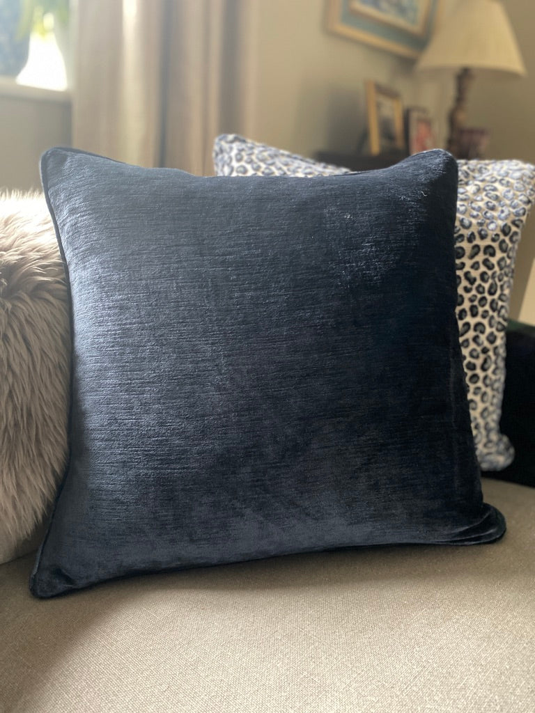 Navy blue cushion on a sofa with a blurred background