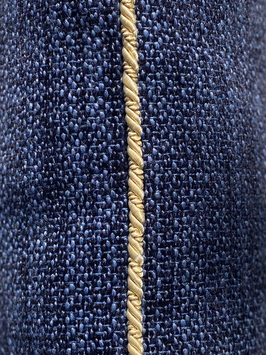 Close-up of  navy chenille cushion showing the gold cord trim