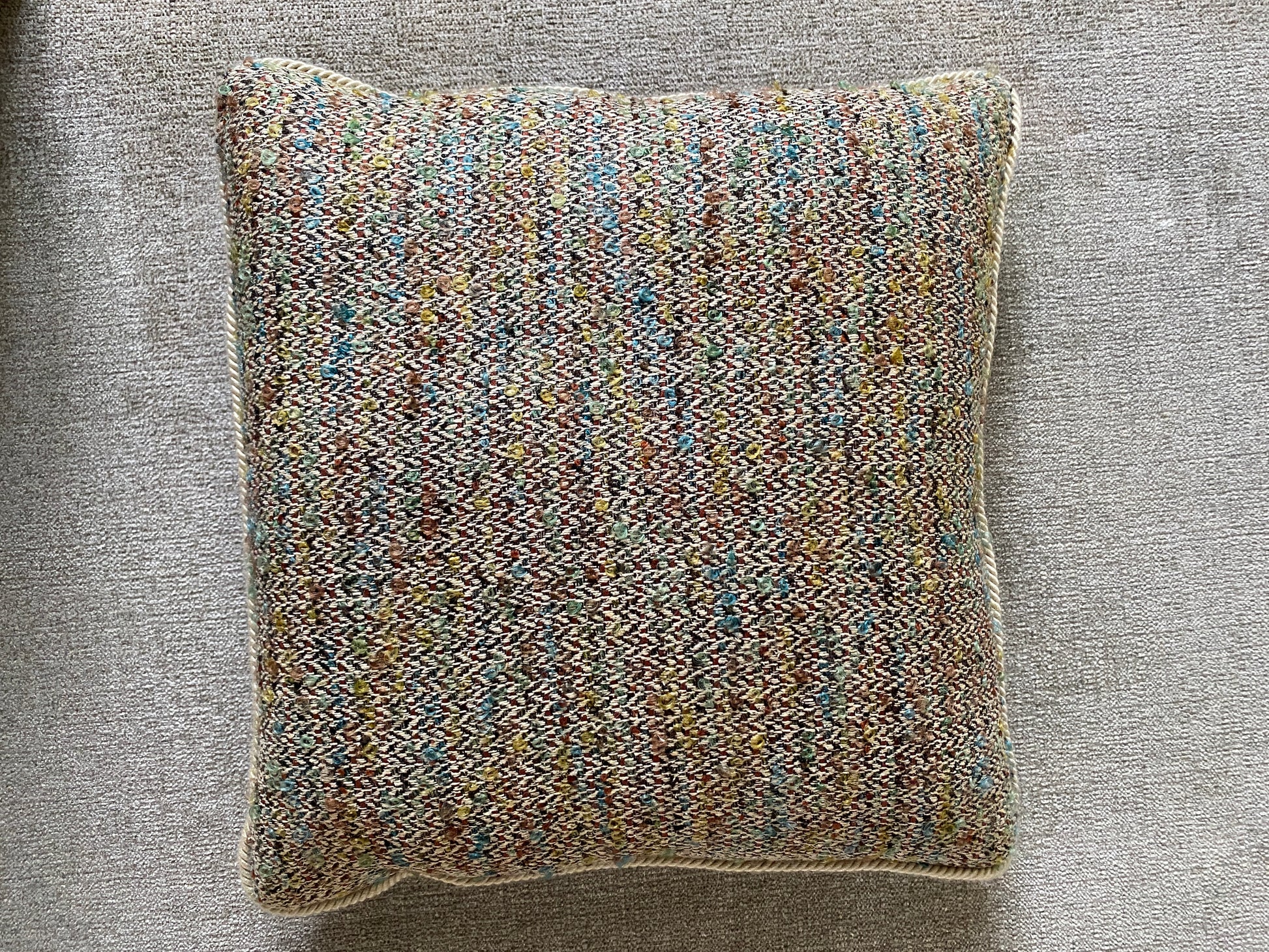 Overhead of a woven cushion on a chenille background