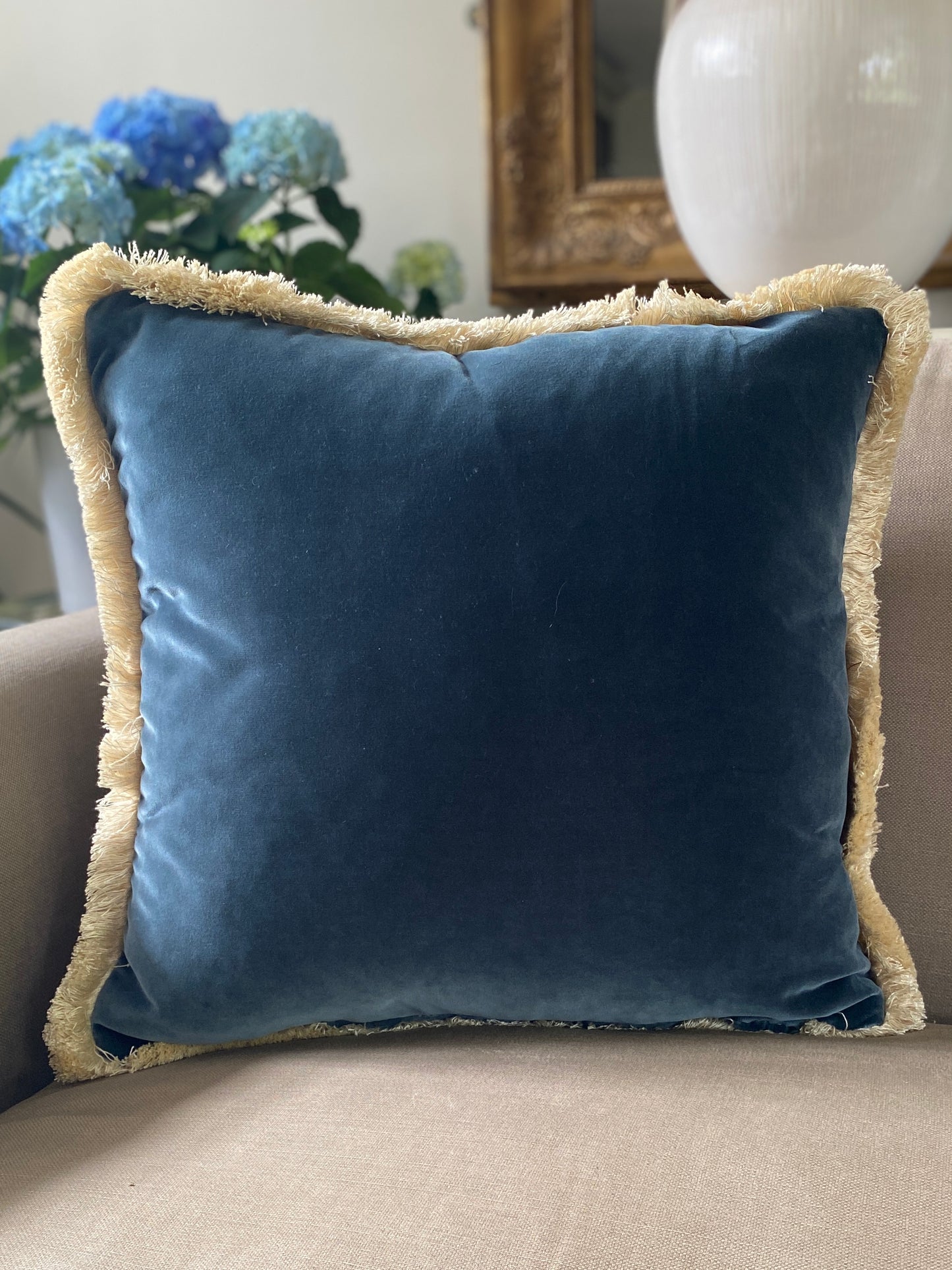Square teal velvet cushion with a complimentary shade of natural fringing.