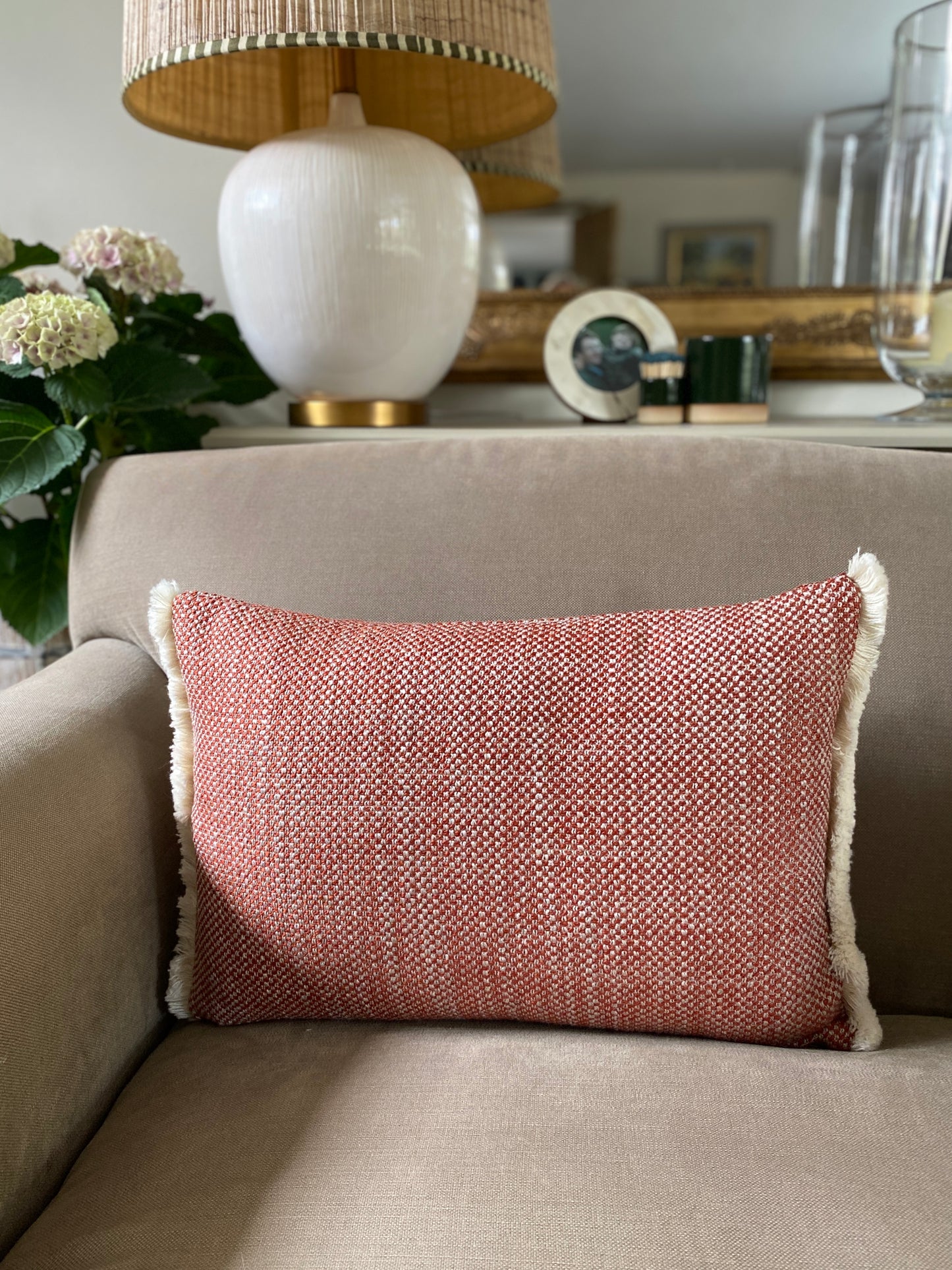 Autumnal chestnut and cream woven textured rectangular cushion with cream wool fringing at each end.