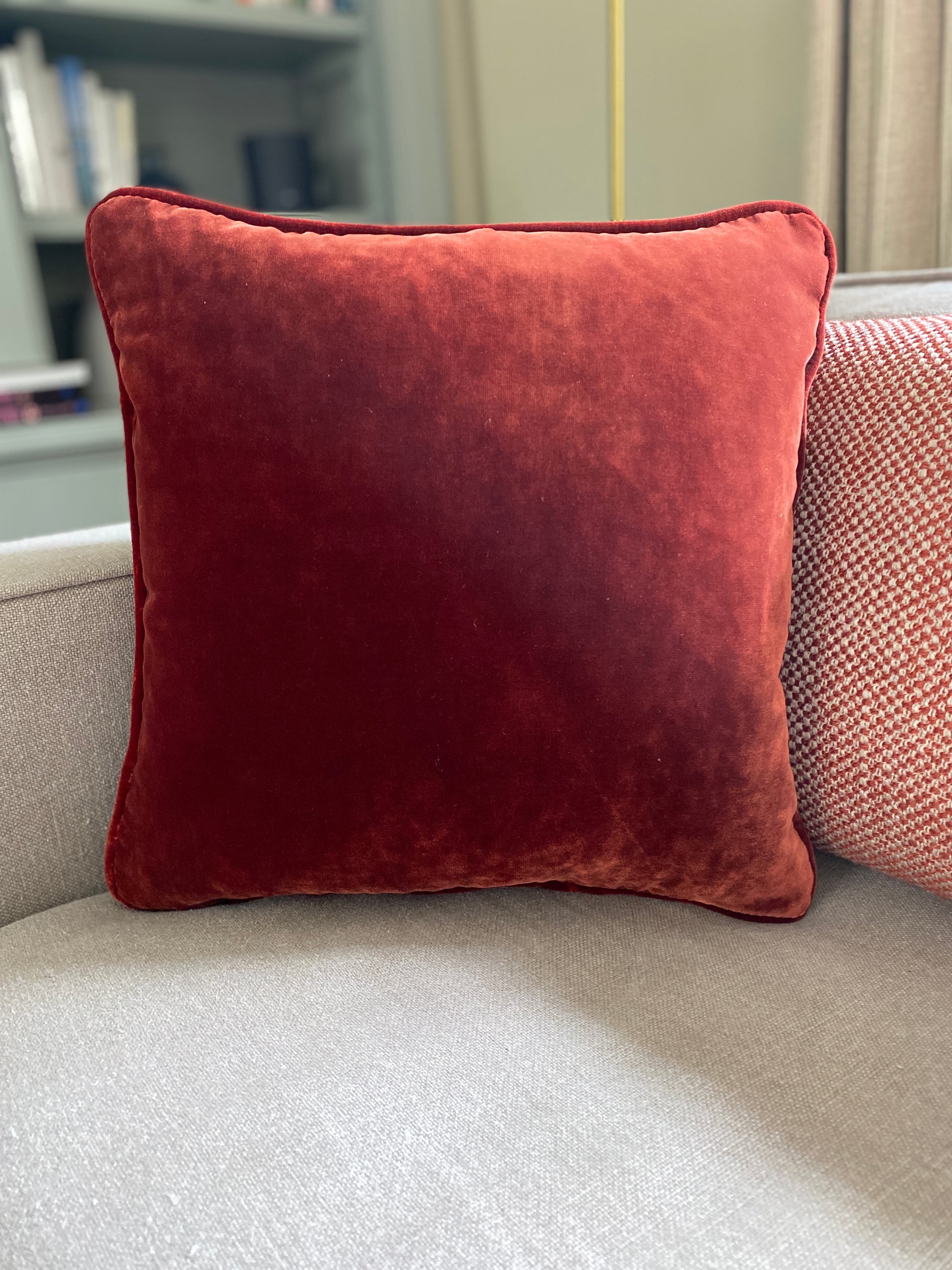 Chestnut velvet square cushion measures 38cm x 38cm and has self piping around the edges. Is shown partnering with a woven rectangular cushion
