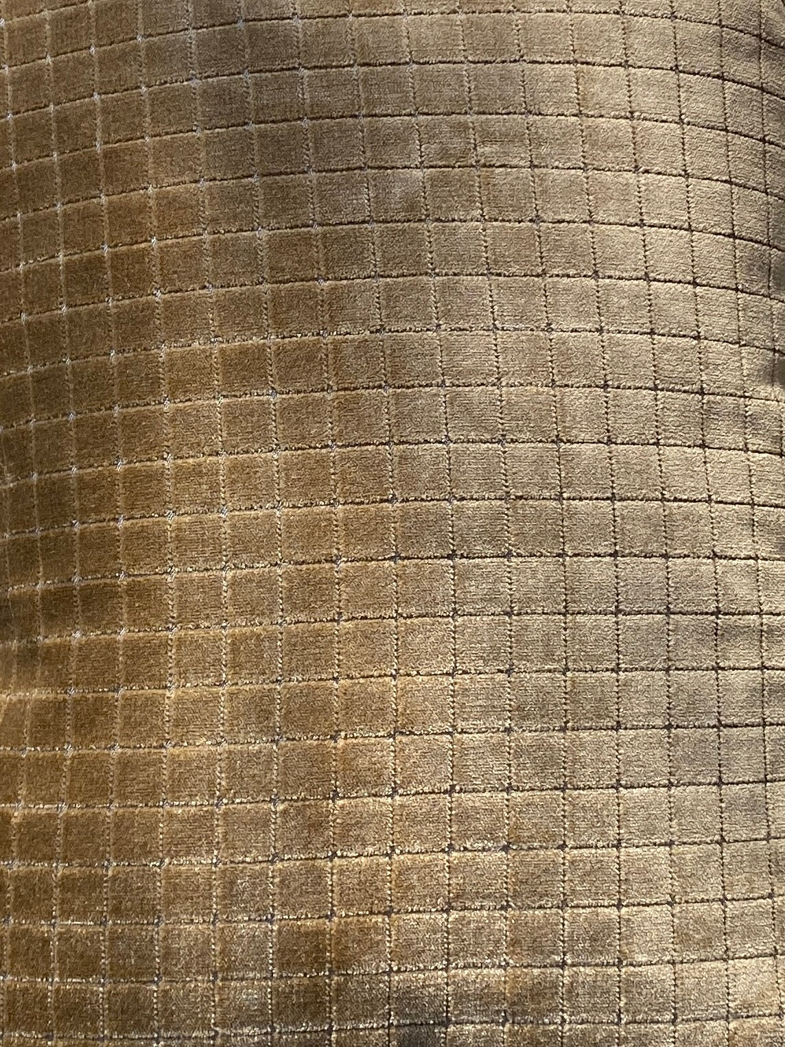 Close-up of textured fabric with a checkered pattern in gold velvet