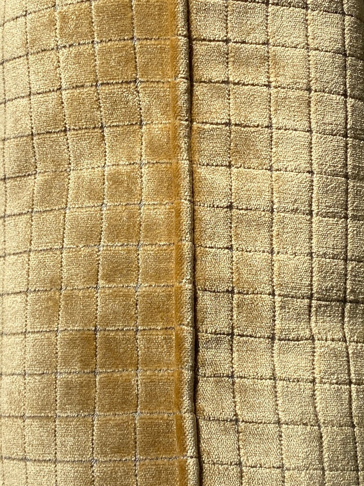 Close-up of textured fabric with a checkered pattern in gold velvet