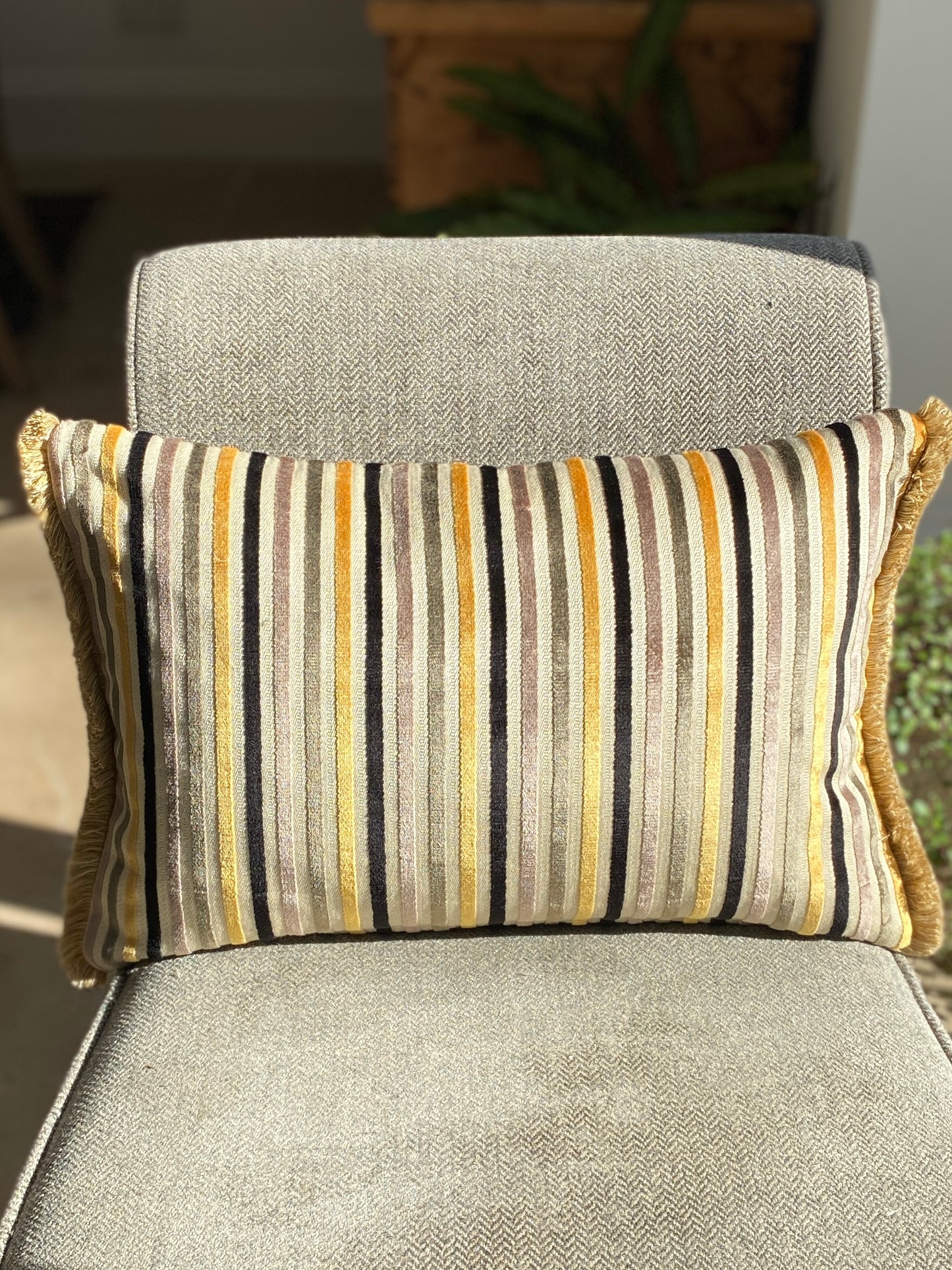 Striped cushion on a grey chair with a blurred background
