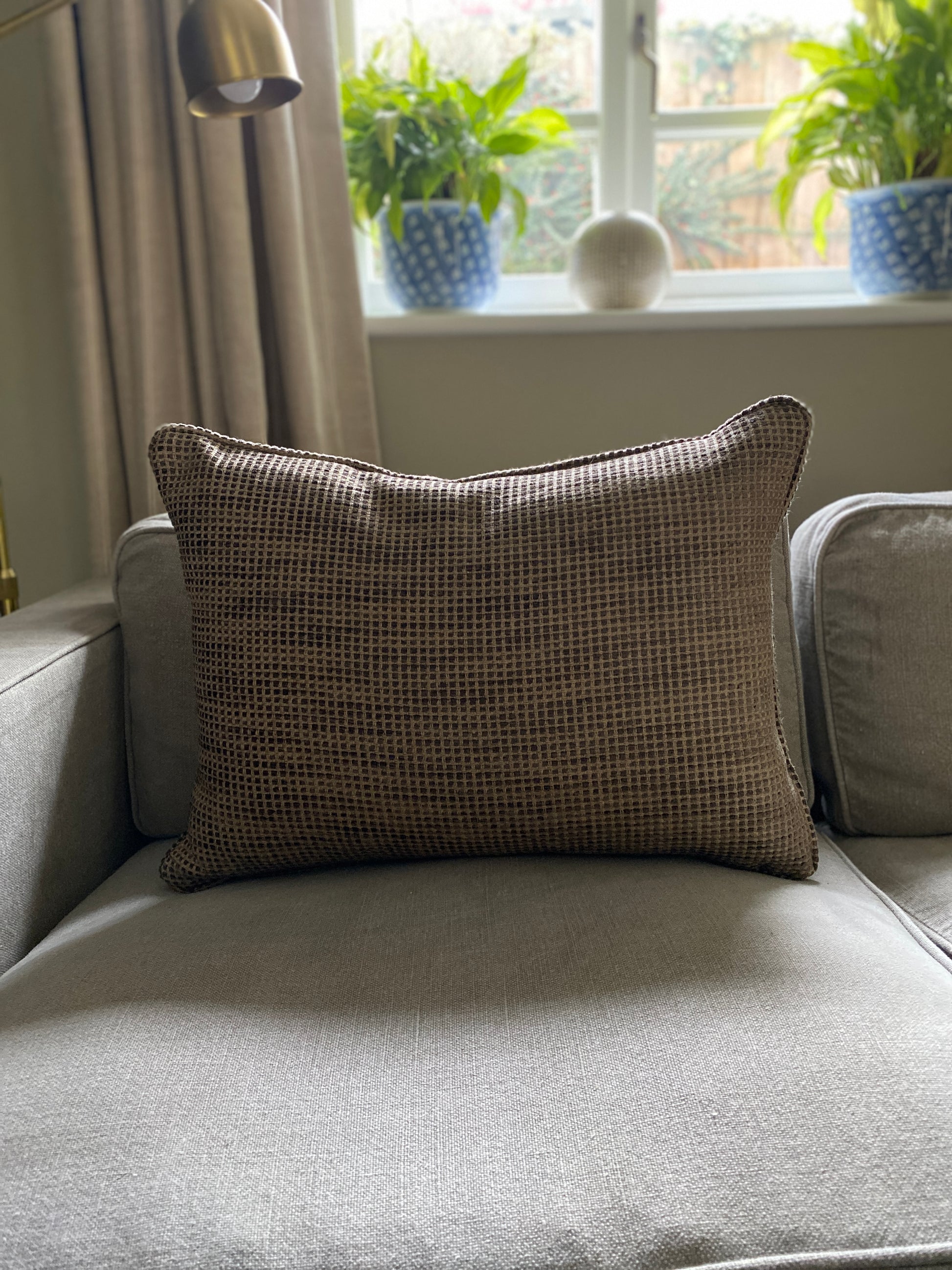 Earthy brown textured chenille rectangular cushion on a sofa.