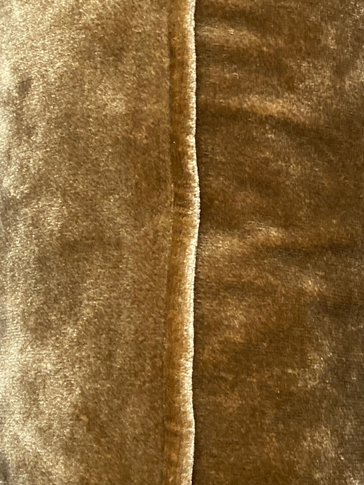 Close up of the antique gold velvet cushion showing the self piped trim.