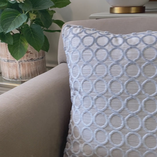 Silver grey cut pile velvet square cushion with silver grey background and circle design. Measures 45 x 45cm and has piping around the edges.